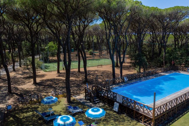 Piscina nel bosco con campi sportivi.