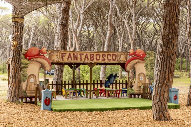 Piccolo parco giochi all'aperto con tavolini colorati e insegna 