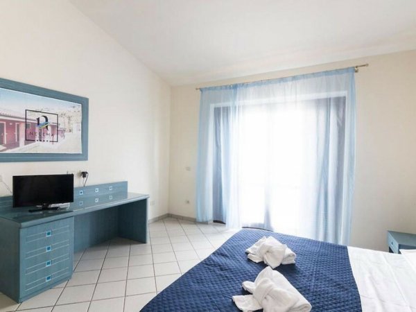 Camera d'albergo luminosa con letto matrimoniale e TV.