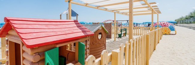 Recinto con casette gioco su sabbia.