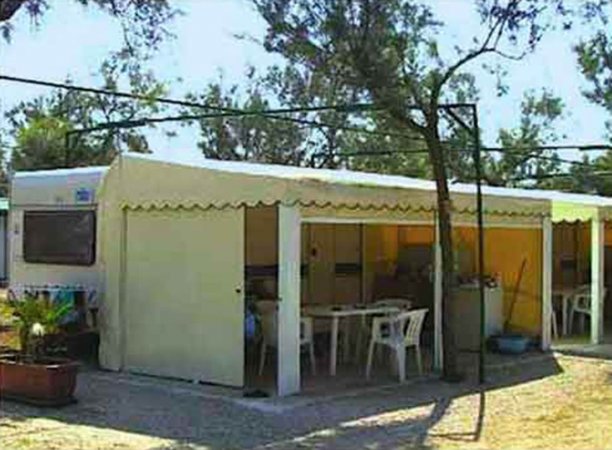 Struttura con tavoli e sedie di plastica.