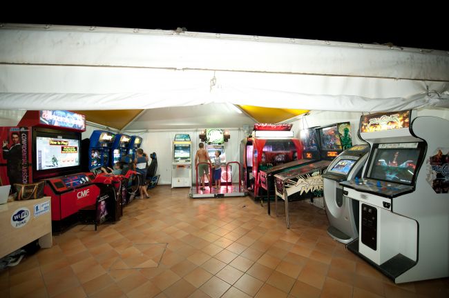Interno di una sala giochi con diverse macchine arcade e giochi elettronici.