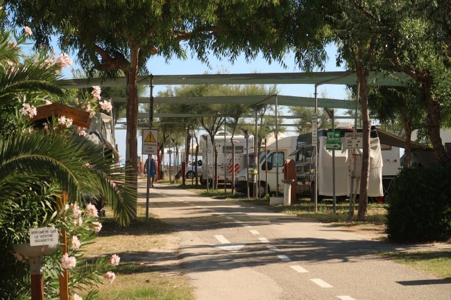 Strada con camper parcheggiati e ombreggiatura.