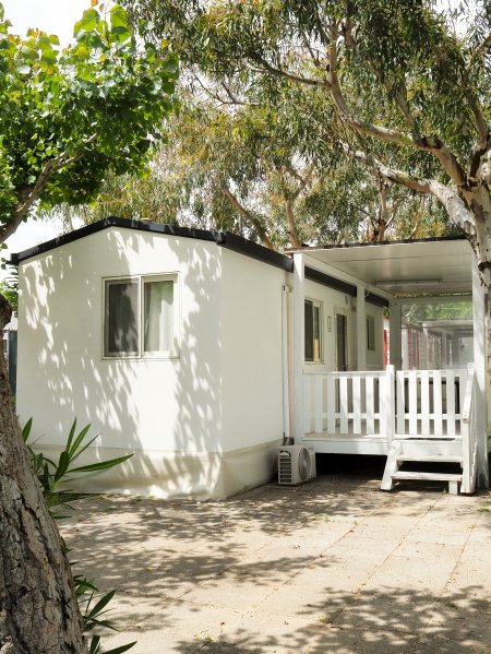 Casa mobile bianca tra gli alberi.