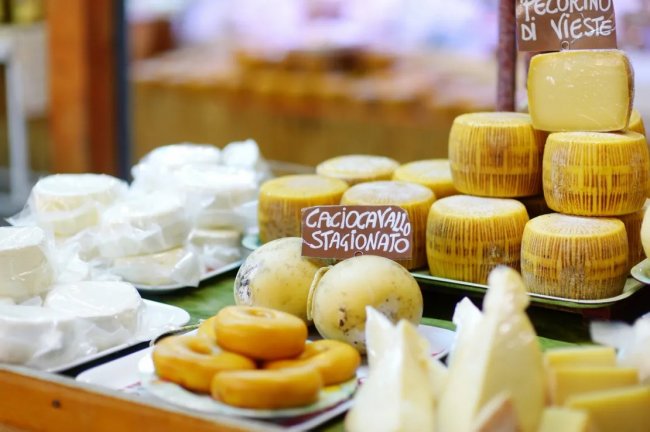 Varietà di formaggi con etichette, tra cui pecorino e caciocavallo.
