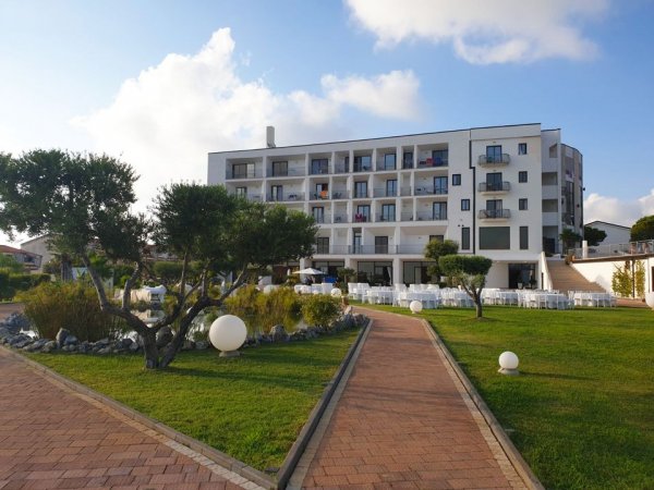 Edificio moderno con giardino e vialetto pavimentato.