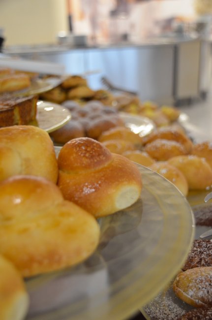 Diversi dolci su un tavolo, tra cui qualche brioche e ciambelle.