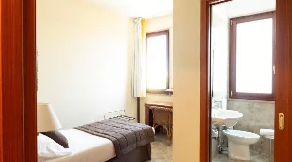 Camera con letto singolo e bagno adiacente.