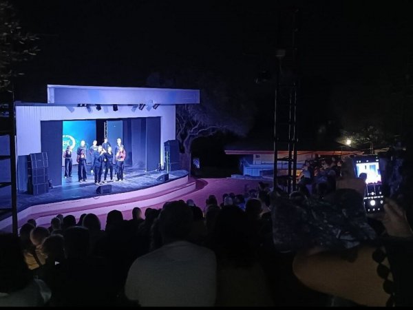 Spettacolo serale su un palco all'aperto.