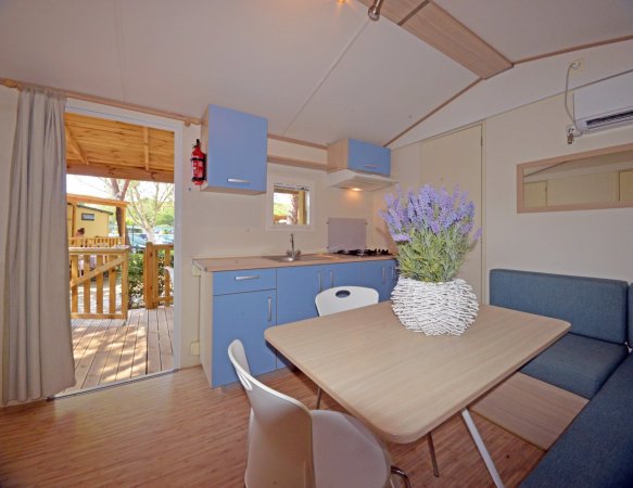 Interno di una casa mobile con tavolo e cucina.