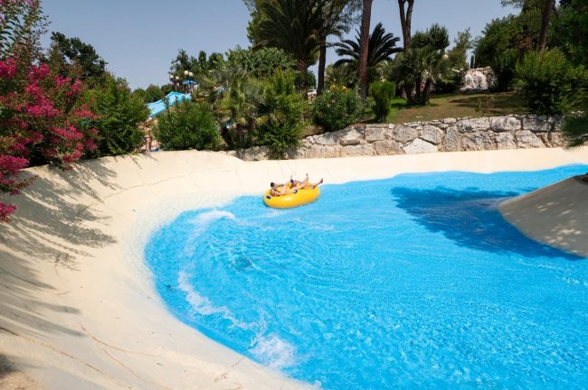 Due persone su un gommone in una piscina con curve.