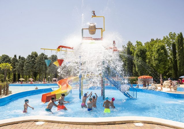 Bambini giocano sotto un secchio d'acqua che si rovescia.