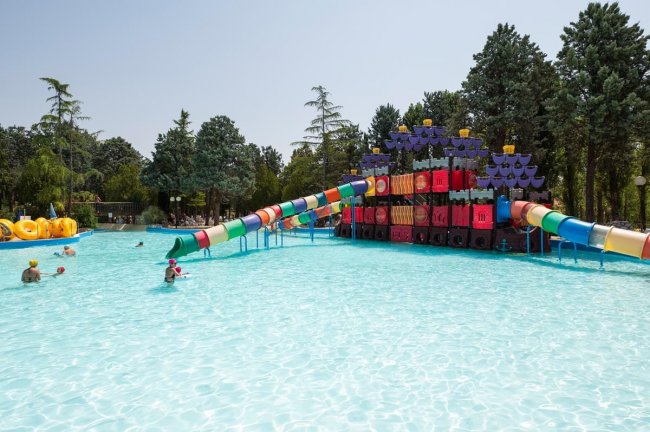 Piscina con scivoli colorati e giochi d'acqua.
