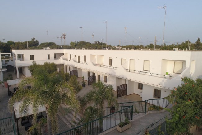 Complesso residenziale bianco con palme.