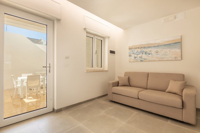 Soggiorno luminoso con divano beige e arte murale.