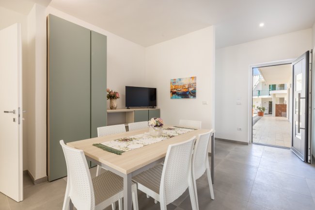 Sala moderna con tavolo da pranzo e TV.