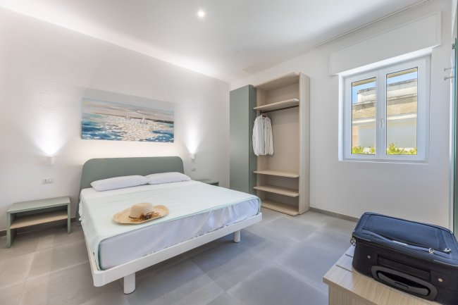 Camera da letto con letto matrimoniale e armadio aperto.