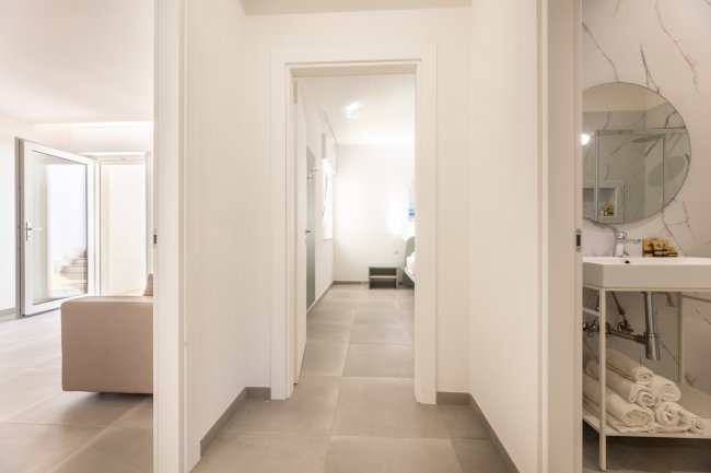 Corridoio con porte verso stanze e bagno.