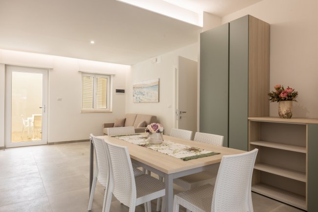 Sala da pranzo moderna con tavolo, sedie e credenza.