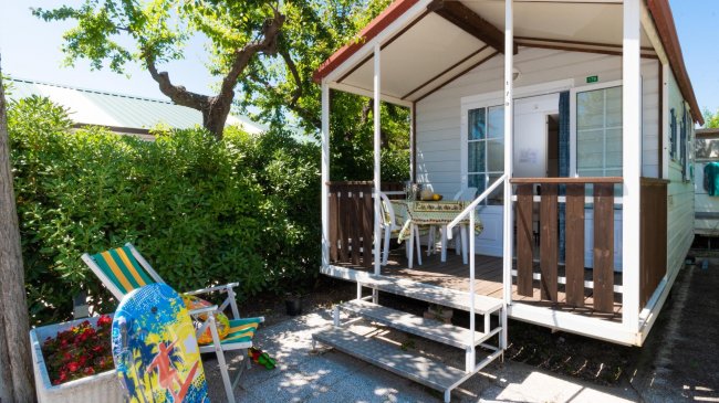 Casa mobile con veranda, sedie e tavolo.