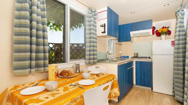 Cucina con tavolo apparecchiato e mobili blu.