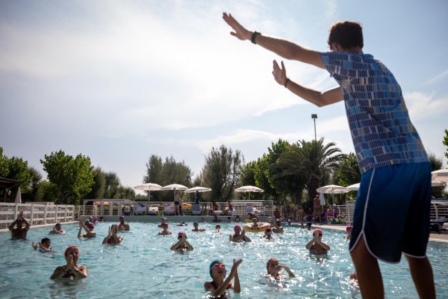 Istruttore guida una lezione in piscina.