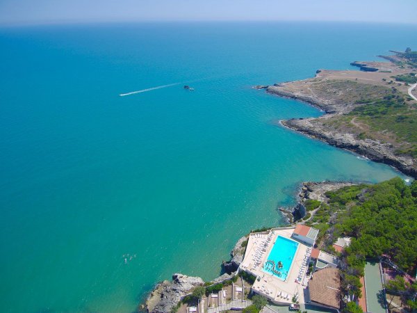 Piscina su scogliera affacciata sul mare turchese.