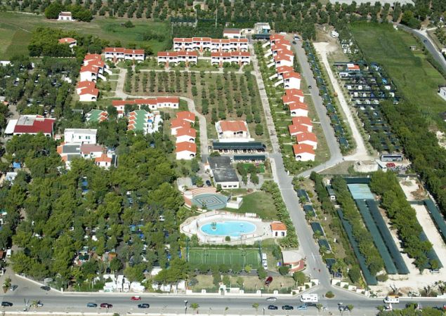 Vista aerea di un complesso con edifici, alberi, strade e un parcheggio.