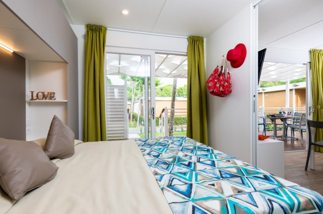Interno di una camera con letto e accesso a un patio esterno.