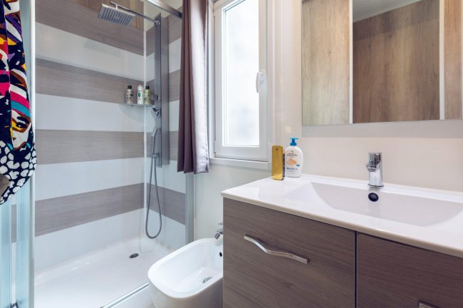 Un bagno moderno con doccia, lavabo e bidet.