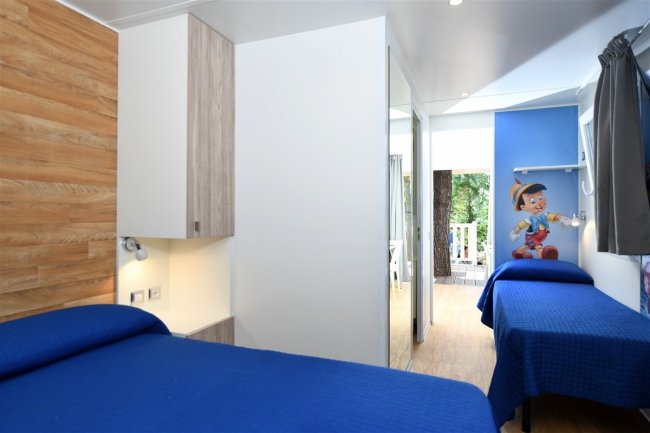 Una stanza con letti blu e poster.
