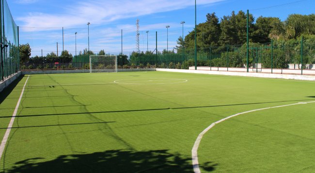 Campo da calcio in erba sintetica, recinto intorno.