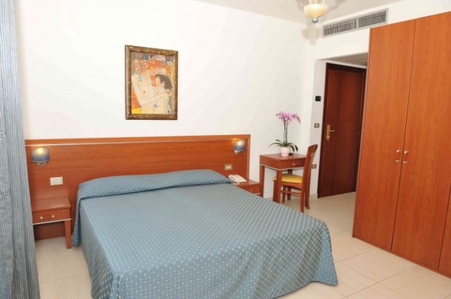 Camera da letto con letto matrimoniale e scrivania.