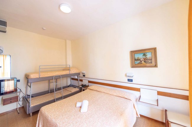 Camera con letto matrimoniale, letto a castello e quadro sulla parete.