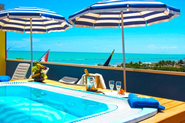 Piscina con ombrelloni a strisce blu e bianche.