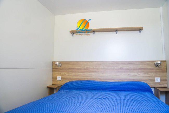 Camera da letto con letto matrimoniale e copriletto blu.