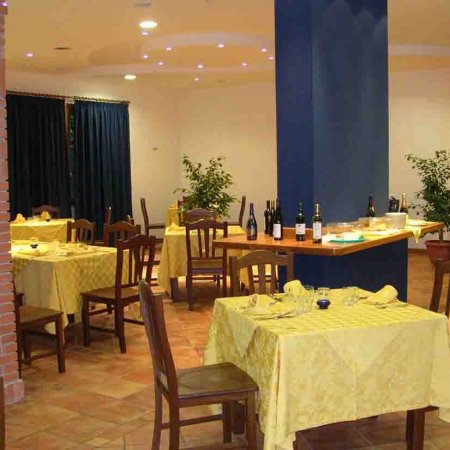 Ristorante con tavoli apparecchiati e piante.