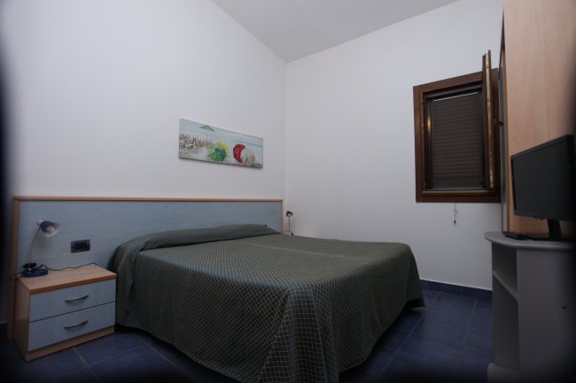 Camera con letto matrimoniale e finestra.