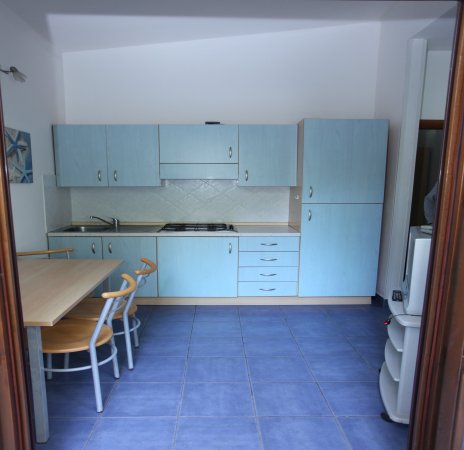 Cucina moderna con mobili azzurri e tavolo.