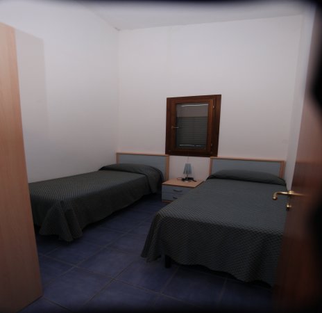 Due letti singoli in una camera con finestrella.
