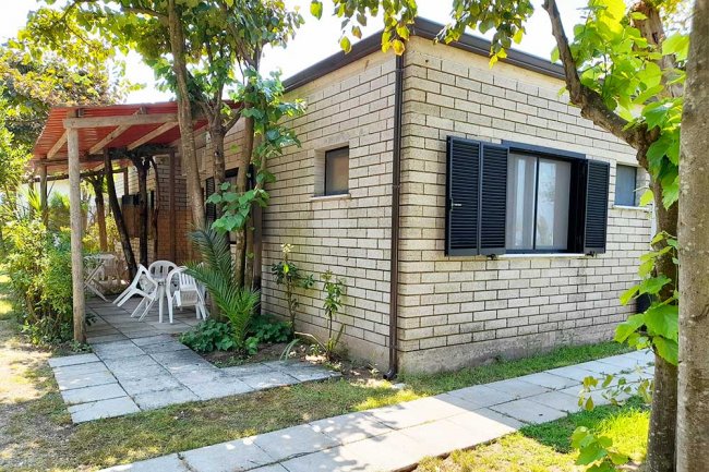 Casetta in mattoni con veranda e giardino esterno.