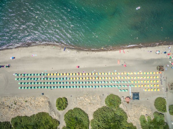 Spiaggia con ombrelloni colorati allineati lungo la sabbia vicino al mare.