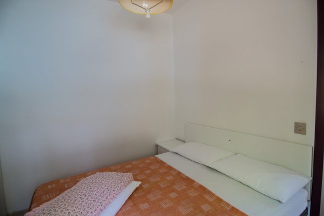 Letto matrimoniale con copriletto arancione.