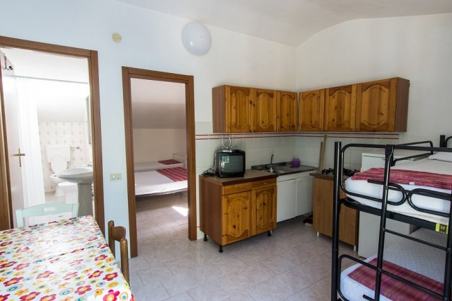 Cucina con letti a castello e tavolo colorato.