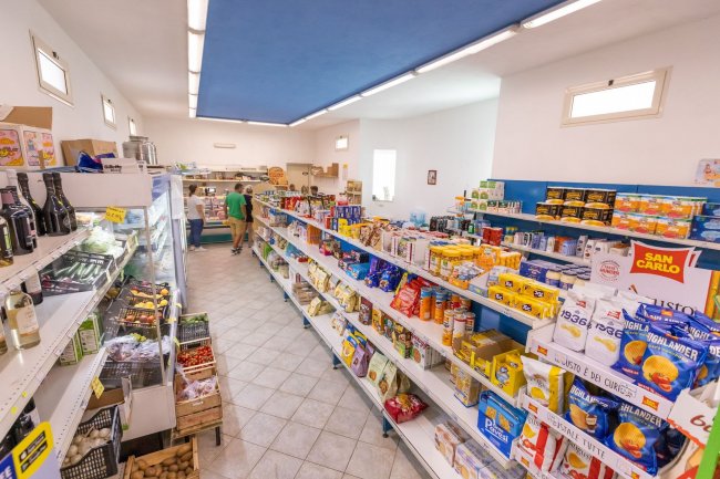 Negozio alimentare con scaffali pieni di prodotti.
