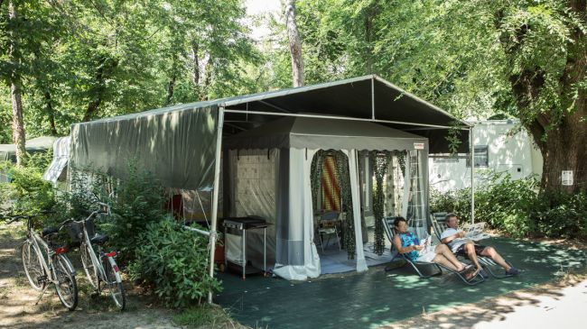 Tenda da campeggio con due persone sedute fuori.