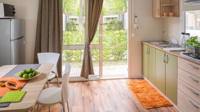 Cucina moderna con tavolo apparecchiato e vista sul giardino.