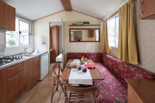 Interno di una casa mobile con cucina e divano a fiori.