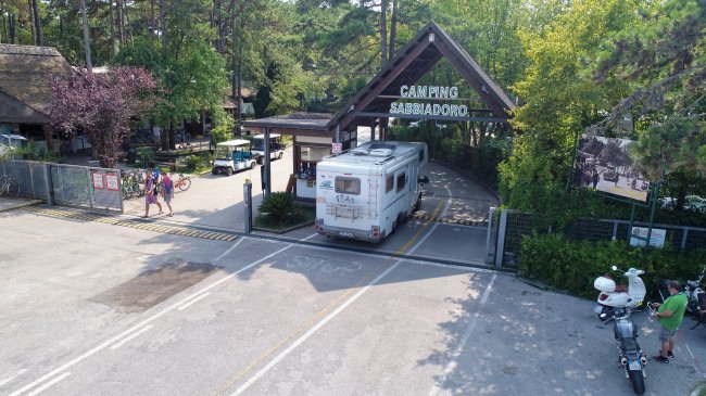Un camper entra nel campeggio con un'insegna 