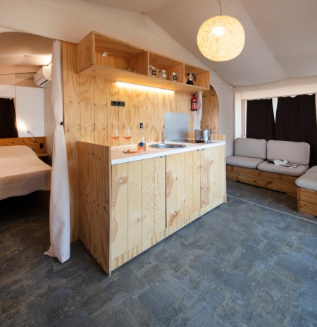 Interno tenda con cucina e divano.